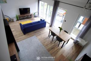 un soggiorno con divano blu e tavolo di Sun&Sport apartament GÓRSKA OSTOJA +prywatna sauna a Szczyrk