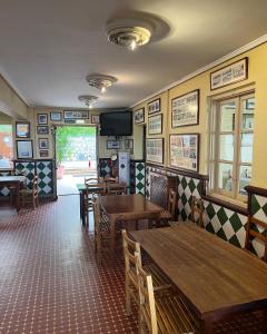 a restaurant with tables and chairs and a tv on the wall at hotel la trainera in Pedreña