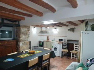 cocina y sala de estar con mesa y sillas en Casa Leonor, en Bel