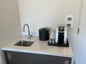a kitchen counter with a sink and a coffee maker at The Orbit Hotel, Trademark Collection by Wyndham in Fairview Park