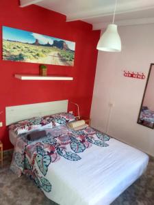 a bedroom with a bed with a red wall at Guest Room Santa Cruz in Santa Cruz de Tenerife