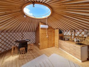uma cozinha numa tenda com uma janela redonda em Jurtafarm Ráckeve - a nomád luxus em Ráckeve