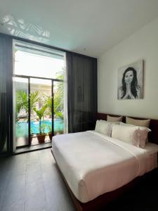 a bedroom with a large bed and a large window at Maison Leab in Siem Reap