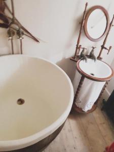 a bathroom with a white tub and a sink at Roselina in Hastings