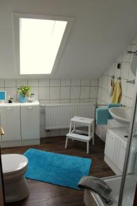 a bathroom with a blue rug and a sink at Ferienwohnung Ausblick in Willingen