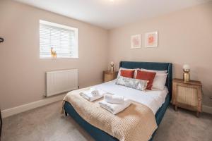 a bedroom with a bed with towels on it at Guildhall Street Apartment in Bury Saint Edmunds