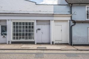 a white building with two garage doors on a street at Guildhall Street Apartment in Bury Saint Edmunds