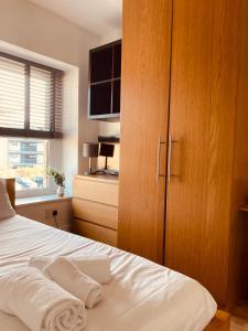 a bedroom with a bed with a large wooden cabinet at 'Bloomfield' at stayBOOM in Lancaster