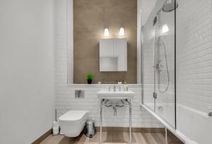 La salle de bains est pourvue d'un lavabo, de toilettes et d'une douche. dans l'établissement Regent's Park Serviced Apartments by MySquare, à Londres