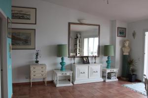 a living room with white furniture and a mirror at Attic in Cadaques in Cadaqués