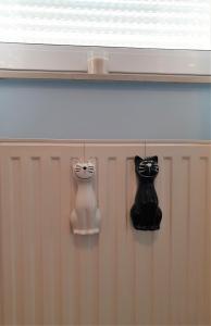 dos decoraciones de gato blanco y negro en una pared en Apartman Silvija, en Osijek