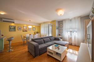 a living room with a couch and a table at Apartman Silvija in Osijek +17 photos