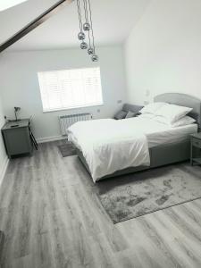 a white bedroom with a bed and a window at The Bay Studio 1 in Broadstairs