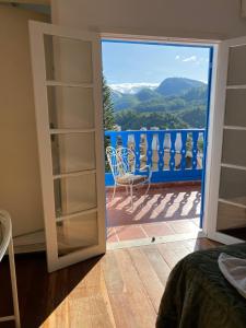 a room with a door open to a balcony with a view at HOTEL MONTANAS in Nova Friburgo