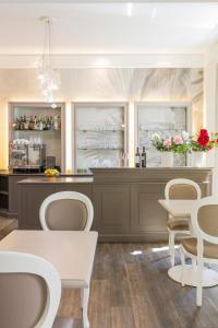 a kitchen with a bar with chairs and a table at Hotel Alexandra in Locarno