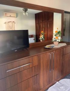 a large wooden entertainment center with a large flat screen tv at Suíte Aconchego in Blumenau