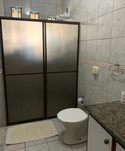 a bathroom with a toilet and a shower stall at Suíte Aconchego in Blumenau