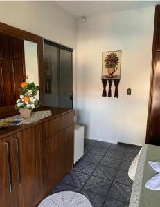 a bedroom with a dresser and a bathroom with a mirror at Suíte Aconchego in Blumenau