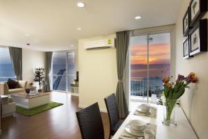 comedor y sala de estar con vistas al océano en BBG Seaside Luxurious Service Apartment, en Bang Saen