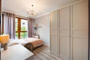 a bedroom with a bed and a window at Prestige Verdant Apartment in Warsaw