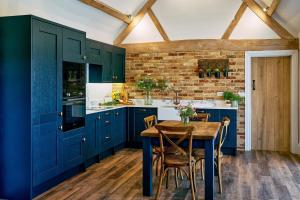 a kitchen with blue cabinets and a wooden table at Stable Barn 