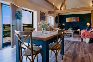 a dining room with a blue table and chairs at Stable Barn 