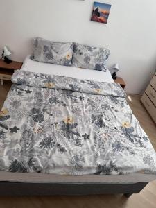 a bed with a black and white comforter on it at Apartment Lili in Blagoevgrad
