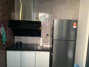 a kitchen with a stainless steel refrigerator and a stove at lmperio Residence Melaka - Private Indoor Hot Jacuzzi in Melaka