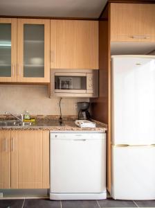 W kuchni znajduje się biała lodówka i kuchenka mikrofalowa. w obiekcie Villa Albufeira w Albufeirze