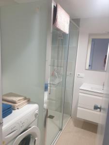 een badkamer met een douche en een wasmachine bij APARTAMENTO EN PRIMERA LINEA DE MAR in Tossa de Mar