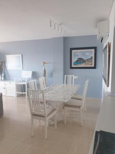 a dining room with a white table and chairs at APARTAMENTO EN PRIMERA LINEA DE MAR in Tossa de Mar