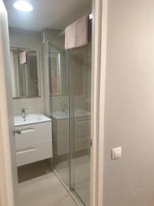 y baño con ducha acristalada y lavamanos. en APARTAMENTO EN PRIMERA LINEA DE MAR, en Tossa de Mar