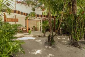 a house with palm trees and a bird in the yard at Dos Ceibas Tulum Feel Good Hotel in Tulum