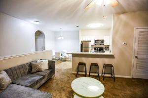 a living room with a couch and a table and a kitchen at Lux 2BD 2BA minutes from the water in Pensacola