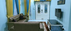 - un salon avec un canapé et une porte dans l'établissement HOMESTAY PAK TEH, à Kota Bharu