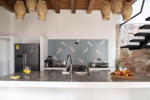 a kitchen with a sink and a counter with a wine glass at Voila Getsemani in Cartagena de Indias