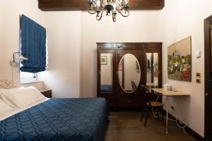 Hotel Villa Dorata في نيكولوسي: غرفة نوم بسرير وطاولة ومرآة