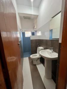 a bathroom with a toilet and a sink at Hotel 100 in Dehiwala