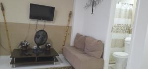 a living room with a couch and a flat screen tv at Loft 2 Quadras da Praia in Rio de Janeiro