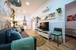 ein Wohnzimmer mit Couch und Flachbildfernseher in der Unterkunft Divi Apartments Martínez Montañes in Sevilla