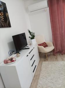 a living room with a tv on a white cabinet at Soft Apartments in Galaţi