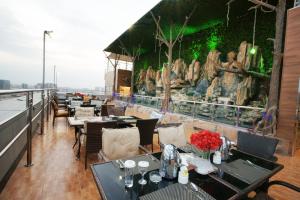 a restaurant with tables and chairs on a balcony at Al Azhar Hotel Jeddah in Jeddah