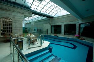 a large swimming pool with a table and a glass ceiling at Al Azhar Hotel Jeddah in Jeddah