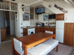 a kitchen with a wooden table and a refrigerator at Playa Del Mar 1 in Margate