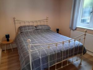 a bedroom with a bed with a blue comforter at Canal View in Todmorden