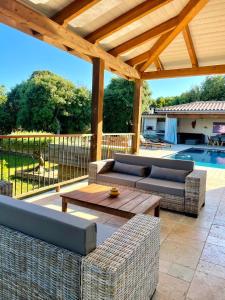 a patio with couches and a table and a pool at Villa Alivu belle piscine chauffée in Bonifacio