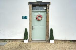 a green door with a wreath on it at Home Farm rooms in the grounds of Wentworth Castle in Barnsley