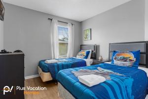 基西米8503-Villa with Pool-Game Room-WiFi by Disney的卧室设有两张床铺,配有蓝色床单 更多37张照片