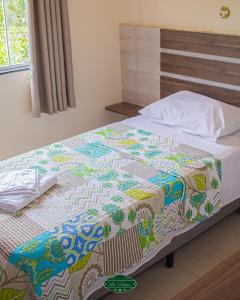 a bed with a colorful quilt on it in a bedroom at La Palma Hotel Fazenda in Indaiatuba