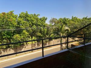 einen Balkon mit Blick auf Bäume und einen Gehweg in der Unterkunft Terrazas Vista Verde in Asunción